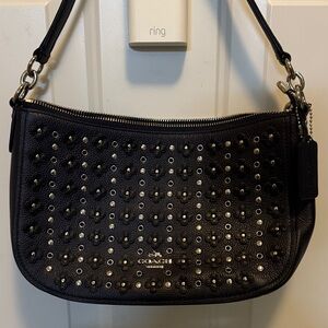 Coach Chelsea crossbody bag with floral rivets.